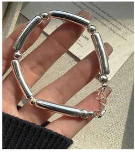 Polished S925 silver minimalist bracelet with lobster clasp on wrist macro view