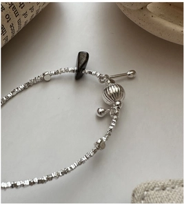 Detail of S925 silver beaded bracelet with dark stone charm and vintage T-bar clasp
