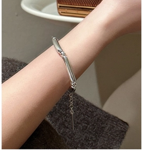 Detailed view of S925 sterling silver minimalist hollow bead bracelet on female wrist