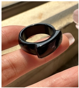 Detailed view of a wide black onyx ring with an asymmetrical sculptural design