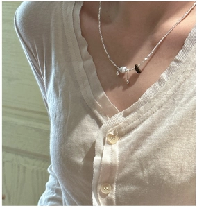 Detailed shot of S925 silver necklace with metallic woven ball and dark mineral pendant