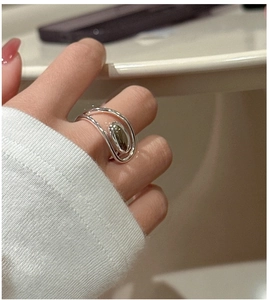 Detailed view of an S925 sterling silver oval ring with artistic layered bands on a finger