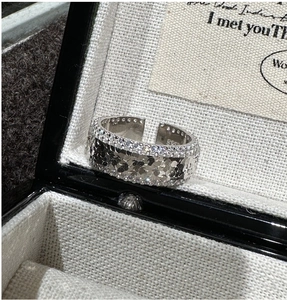 Macro shot of S925 sterling silver ring with pavé zircon borders and hammered texture