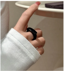 Detail of minimalist black agate ring with a glossy finish worn on a finger