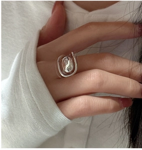 Detailed view of an irregular oval silver ring with a liquid metal flow aesthetic