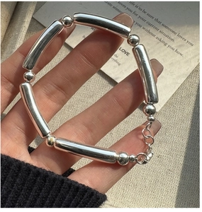 Detailed shot of S925 silver beaded bracelet with polished tubes and lobster clasp closure