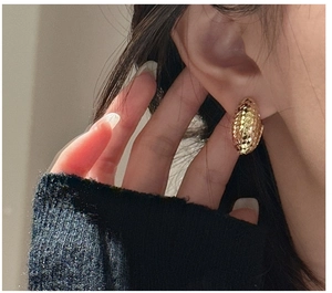 Detailed view of golden S925 sterling silver earrings with textured diamond-cut finish