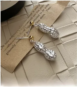 Détail des boucles d'oreilles cacahuète en argent sterling S925 sur papier vintage