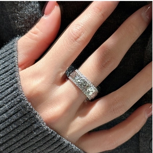 Macro shot of silver ring with three rows of pavé zircons worn on hand close-up