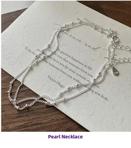 Detail of S925 sterling silver beaded chain necklace with adjustable clasp and logo tag