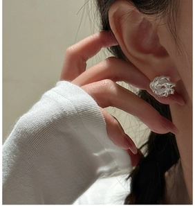 Close-up of S925 sterling silver woven knot stud earrings on a model ear