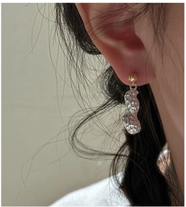 Détail de boucles d'oreilles en argent en forme d'arachide sur un mannequin