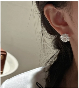 Close-up of S925 sterling silver rose knot earrings worn by a model with elegant matte finish