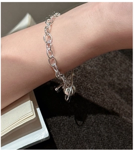 Detailed view of an S925 silver beaded bracelet with a planet charm worn on a wrist