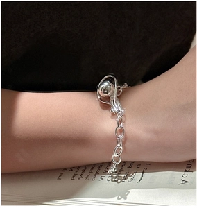 Detail of S925 sterling silver beaded bracelet with orb pendant on a female wrist