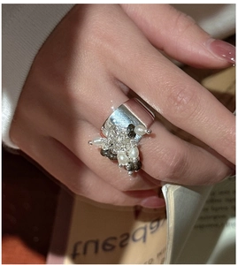 Dettaglio macro dell'anello largo in argento S925 con perle bianche e accenti di pietre