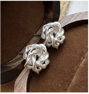 Macro shot of S925 sterling silver matte rose earrings in a vintage jewelry box
