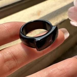 Minimalist black agate ring with polished geometric design worn on a finger