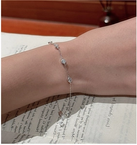 Gros plan d'un bracelet délicat en argent S925 avec cinq zircons ronds sur un poignet