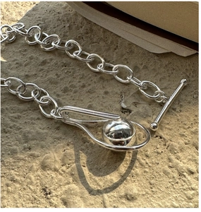 Detailed view of silver OT toggle clasp with sphere charm on minimalist chunky chain