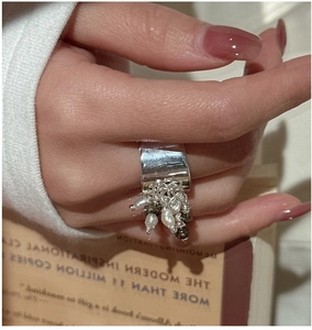 Dettaglio anello in argento retrò con nappe di perle d'acqua dolce su uno sfondo caldo