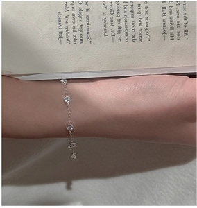 Gros plan d'un bracelet en argent S925 avec perles de zircon porté délicatement au poignet