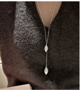 Macro view of S925 sterling silver Y-shaped necklace with brushed metal pendant on a model