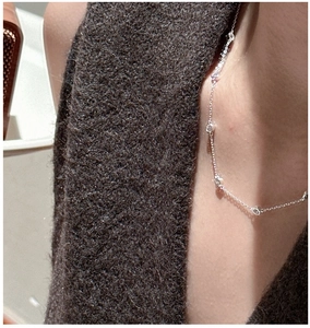 Detail of S925 sterling silver chain necklace with shimmering zircon beads on a neckline