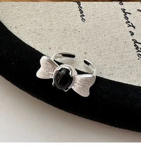 Macro shot of S925 silver butterfly ring with black onyx and brushed metal texture
