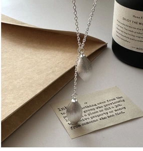 Macro view of S925 silver Y-shaped necklace featuring dual brushed teardrop pendants
