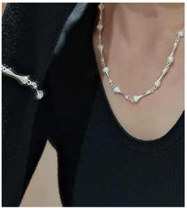 Gros plan d'un ensemble collier et bracelet vintage en argent mat texturé sur un mannequin