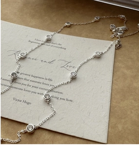 Macro shot of S925 sterling silver chain with bezel-set cubic zirconia on vintage card