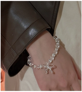 Détail du bracelet en perles d'argent S925 avec cristal blanc et nœud métallique