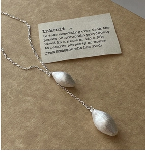 Macro detail of S925 sterling silver water drop pendant with brushed metallic texture
