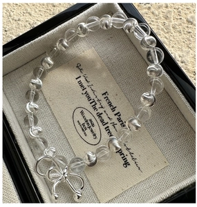 Gros plan d'un bracelet en perles d'argent S925 avec nœud œil de chat dans son coffret
