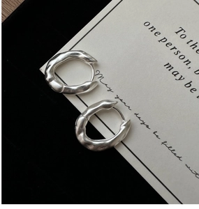 Detailed close-up of S925 silver earrings with irregular matte lava texture design