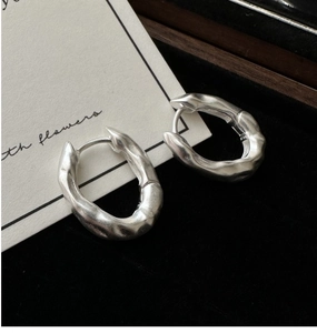 Macro shot of S925 silver earrings with irregular lava texture and matte finish