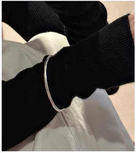 Close-up of a minimalist S925 sterling silver bangle with irregular handmade lines