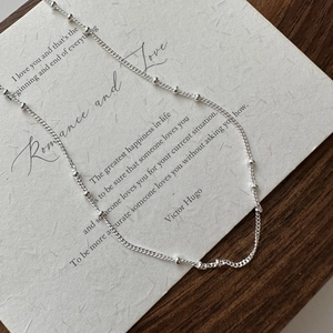 Minimalist S925 sterling silver beaded saturn chain necklace on a poetic paper background