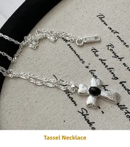 Makro-Detail des S925 Silberkreuz-Anhängers mit schwarzem Onyx auf Vintage-Leinen