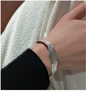 Détail d'un bracelet jonc en argent S925 avec texture martelée porté par un mannequin