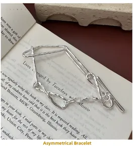 Detailed shot of an irregular S925 silver knot bracelet on vintage book pages