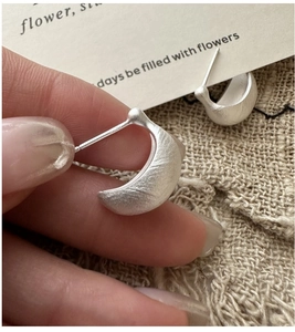 Close-up of S925 sterling silver hoop earrings with a matte brushed texture finish