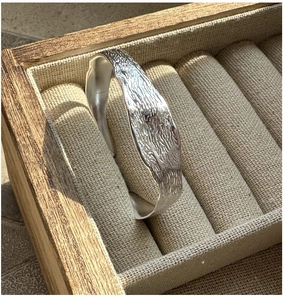 Vue macro d'un bracelet jonc en argent S925 avec texture écorce d'arbre vintage