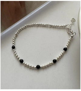 Vue macro détaillée du charme en argent S925 et perles d'onyx noir de style vintage