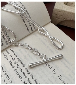 Macro view of S925 sterling silver knotted toggle clasp and irregular chain links