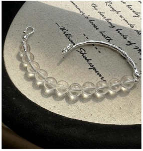 Macro shot of silver bracelet with clear crystals on vintage book background