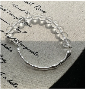 Detail of S925 silver bracelet with white crystal beads on a vintage book background