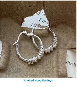 Détail macro de boucles d'oreilles créoles nouées en argent S925 avec poinçon net