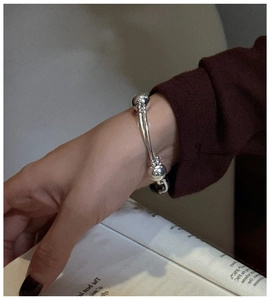 Detail of S925 sterling silver double-layer twisted bangle with polished metal beads